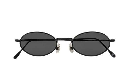 Vista frontale degli occhiali rotondi modello Marie, con montatura nera opaca e lenti color grigio scuro, chiusi